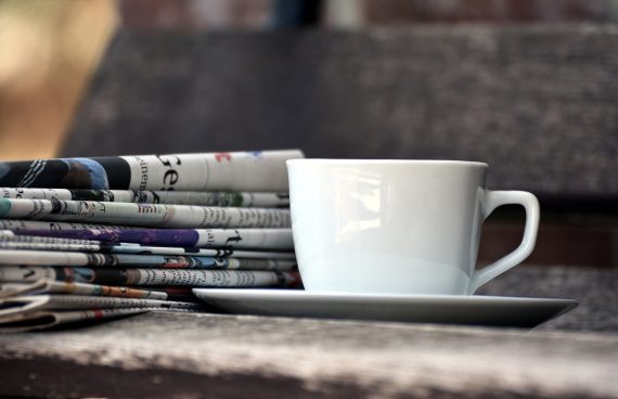 Eine Tasse und Zeitungsseiten